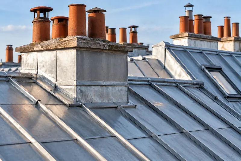 Toiture en zinc autour d’une souche de cheminée habillée de zinc